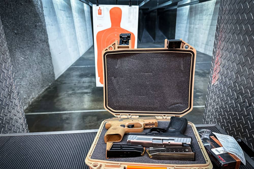 Illustrative stock photo: an open hard case holding a handgun and accessories at an indoor range