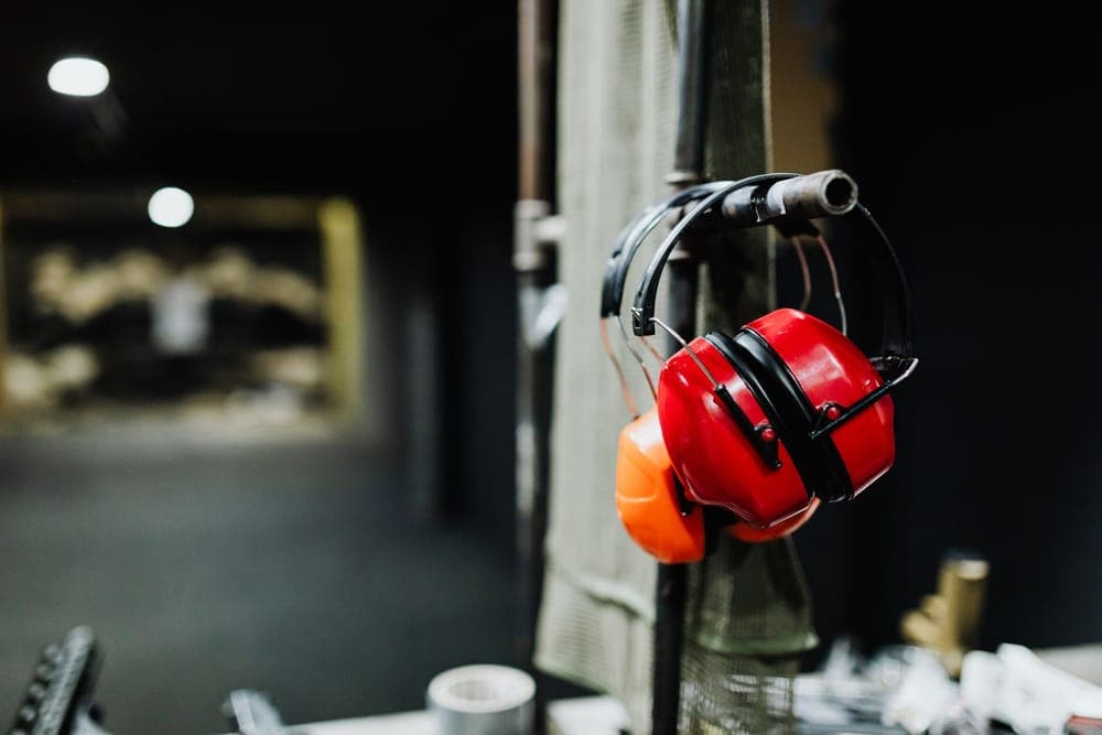 Illustrative stock photo: red earmuffs hanging at an indoor shooting range