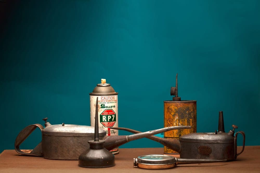 Vintage oil cans and a spray can on a wooden table