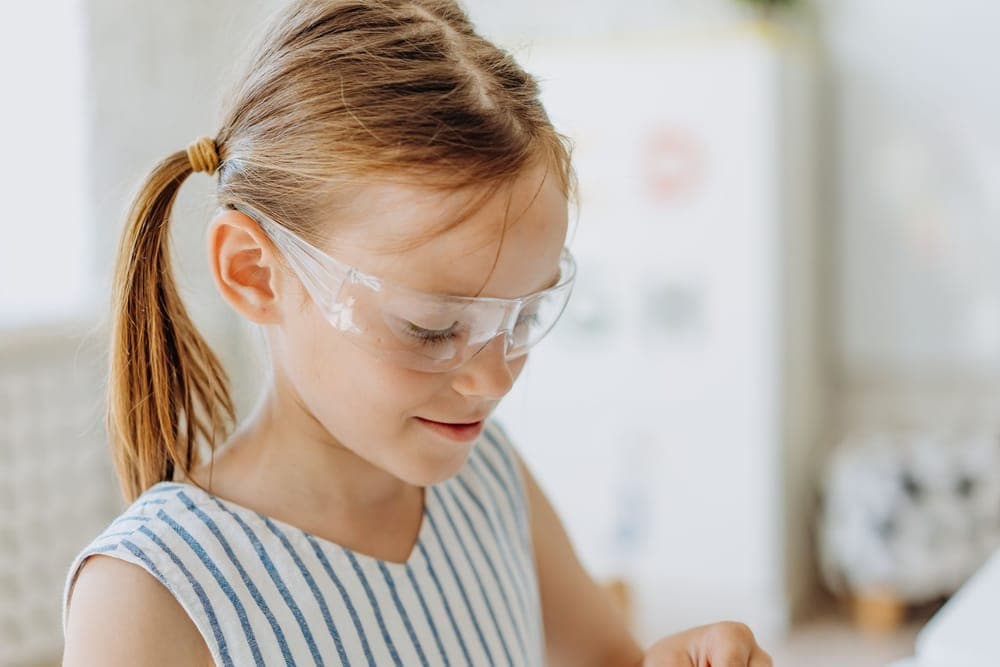 A young girl wearing clear protective glasses